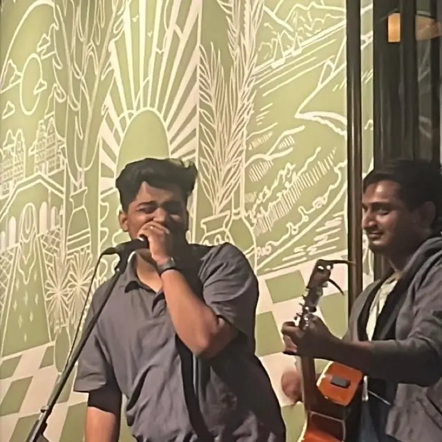 Singing on stage with a guitarist at a live music night